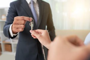 Hand of woman taking keys from hand of real estate owner